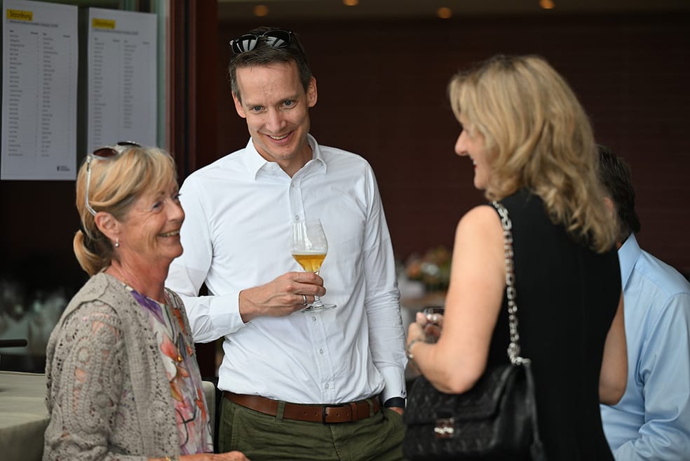 3 Personen stehen beim Apéro beieinander